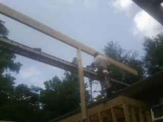 Carpenter setting a ridge beam over a new addition frame — Ice Dam Removal by Roofing Brothers in Zanesfield