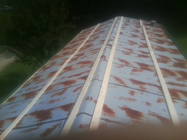Rusted metal roof panels with new wood purlins before replacement — Storm Damage Roof Repair in Zanesfield by Roofing Brothers