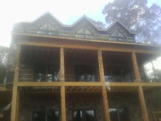 Dormers and porch framing on a large log home under construction — Roof Coating work by our crew in Zanesfield