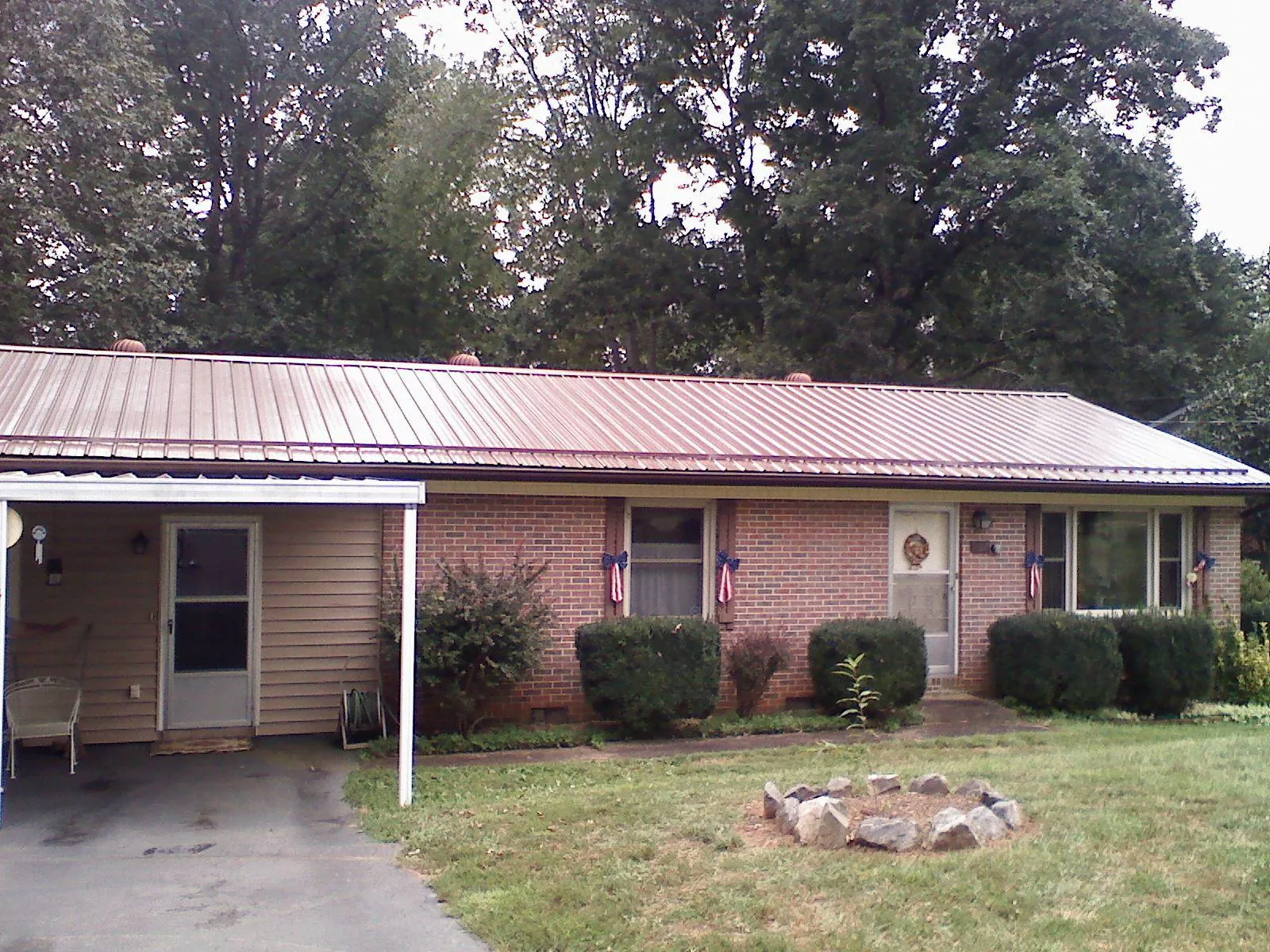 Bronze metal roof and carport on a brick ranch home — Roof Repair work by our crew in Zanesfield