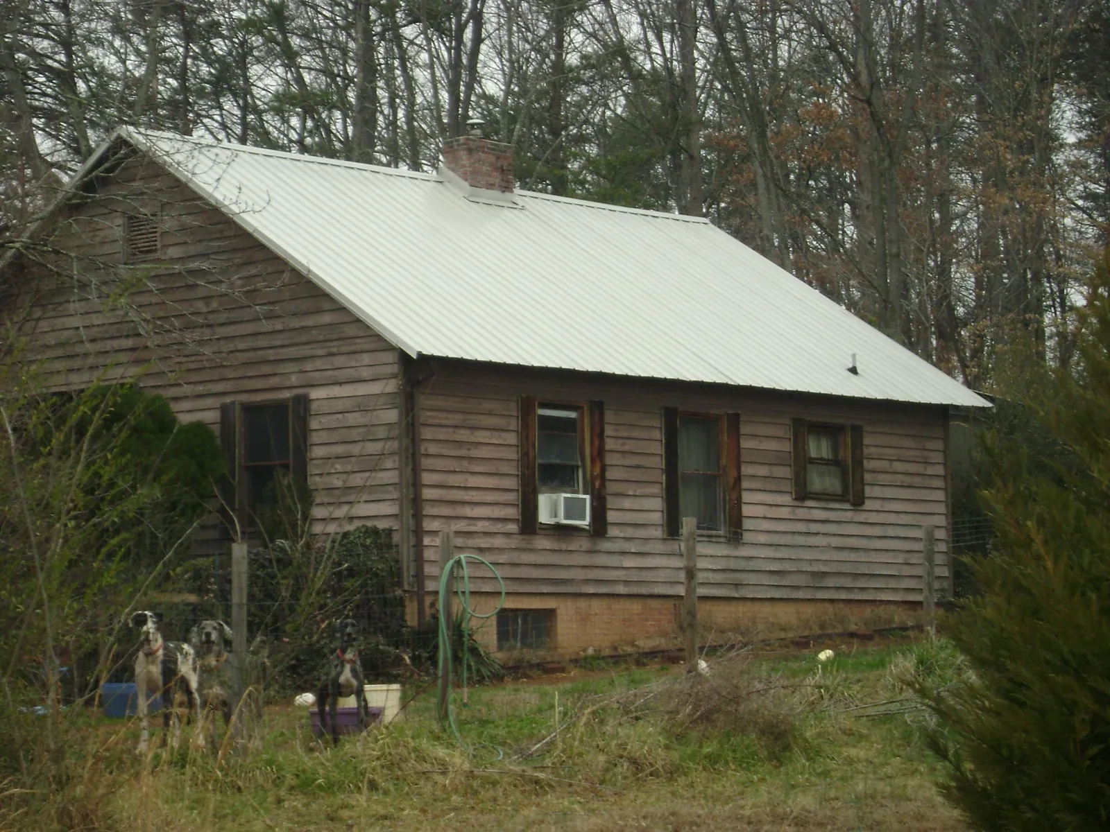 White metal roof on an old wood sided farmhouse, from a Metal Roof Installation job in Zanesfield